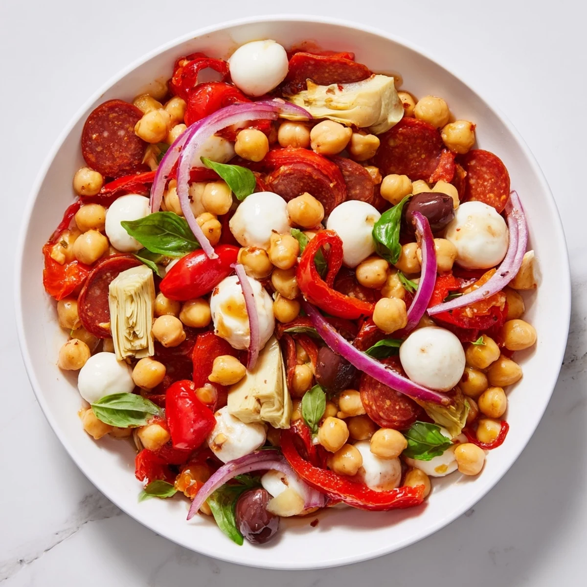 This refreshing Antipasto Chickpea Salad showcases bright red tomatoes and zesty pepperoni on a bed of chickpeas.