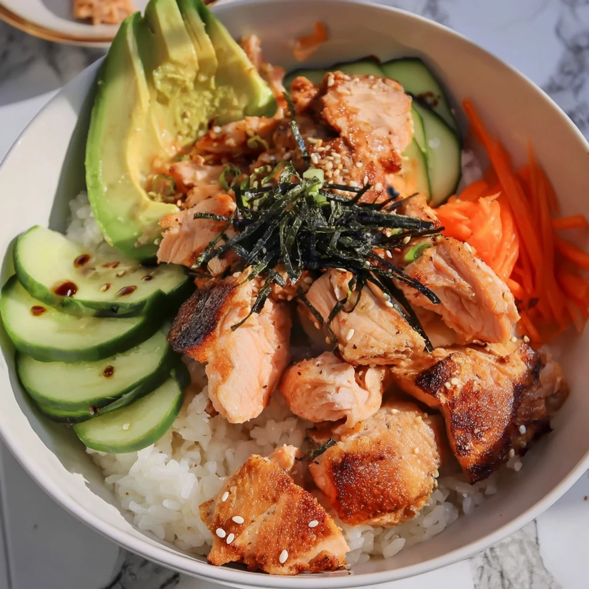 A close-up view displaying a colorful Japanese-style salmon & chicken rice bowl overflowing with textures.