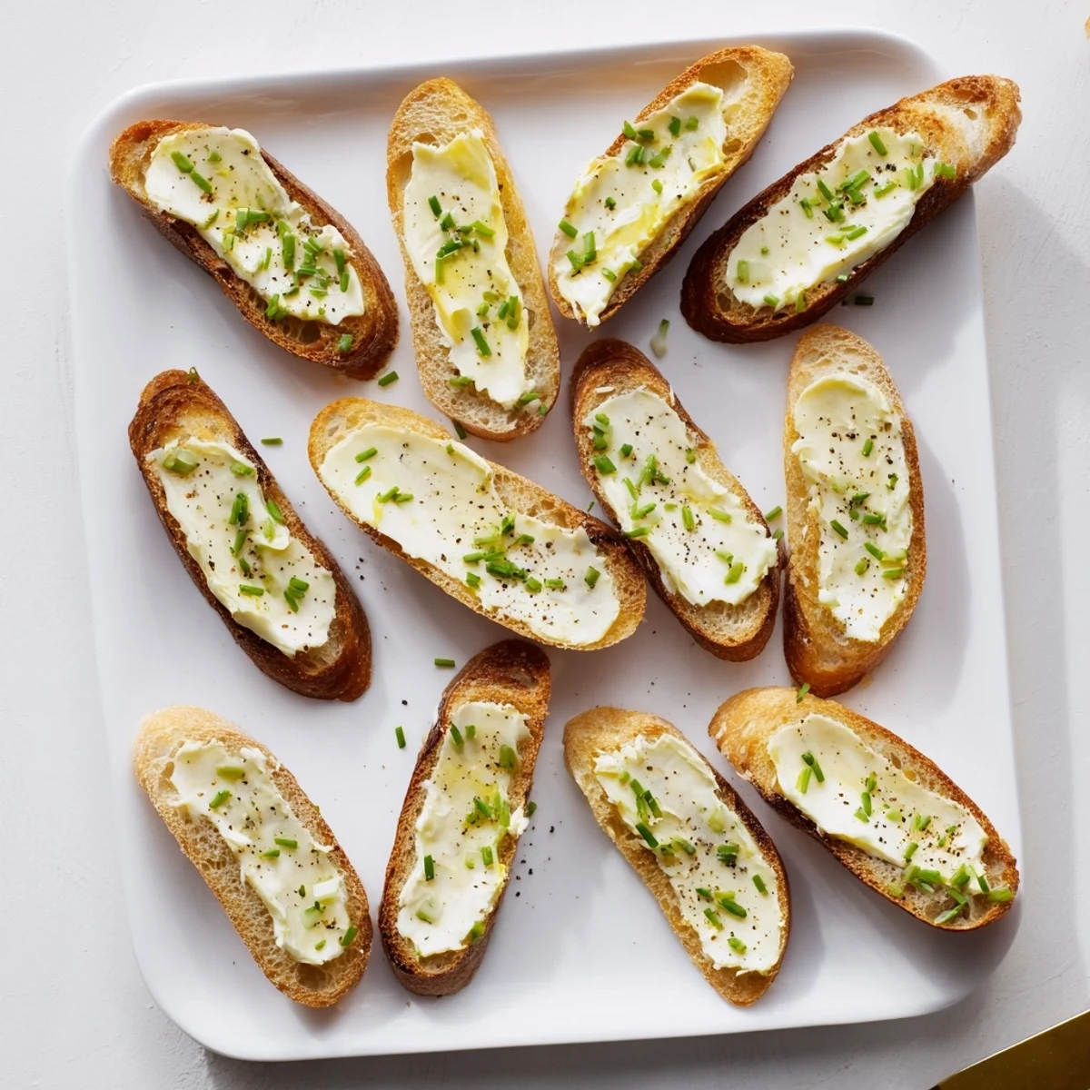 Close-up of buttery vodka-infused crostini with a delicate pepper sprinkle, ready to serve alongside smoked salmon or radishes.  