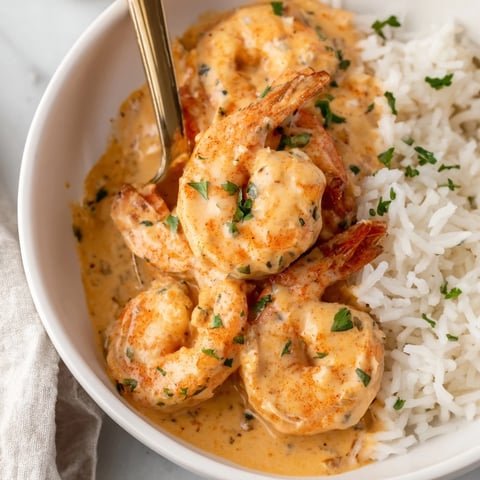 Plump Cajun shrimp glisten in a rich, creamy sauce served over a fluffy bed of fragrant jasmine rice.