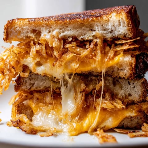 A close-up of the Crispy Onion Grilled Cheese revealing gooey cheese and crunchy onion layers.  
