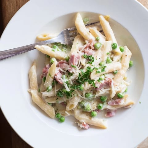 A hearty, comforting plate of Spring Pea & Ham Pasta featuring sweet peas and diced ham mixed into penne.