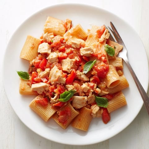 Steaming bowl of Tomato Basil Chicken Pasta tossed in a rich red tomato sauce.
