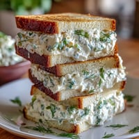 Creamy cucumber and cream cheese Benedictine tea sandwiches arranged on a white platter, perfect for Derby parties.